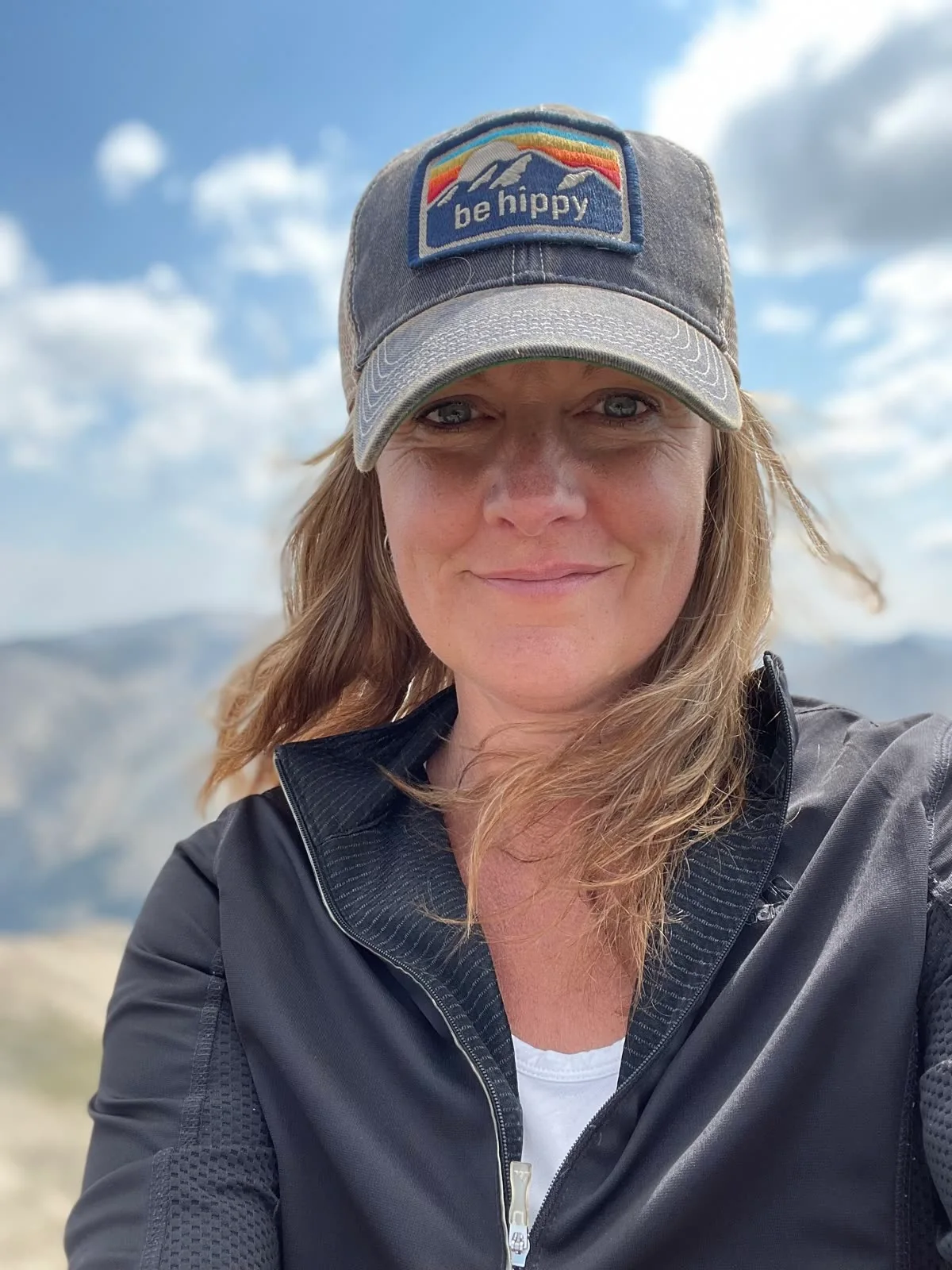 Laura Parker wearing a cap outdoors in the Colorado mountains