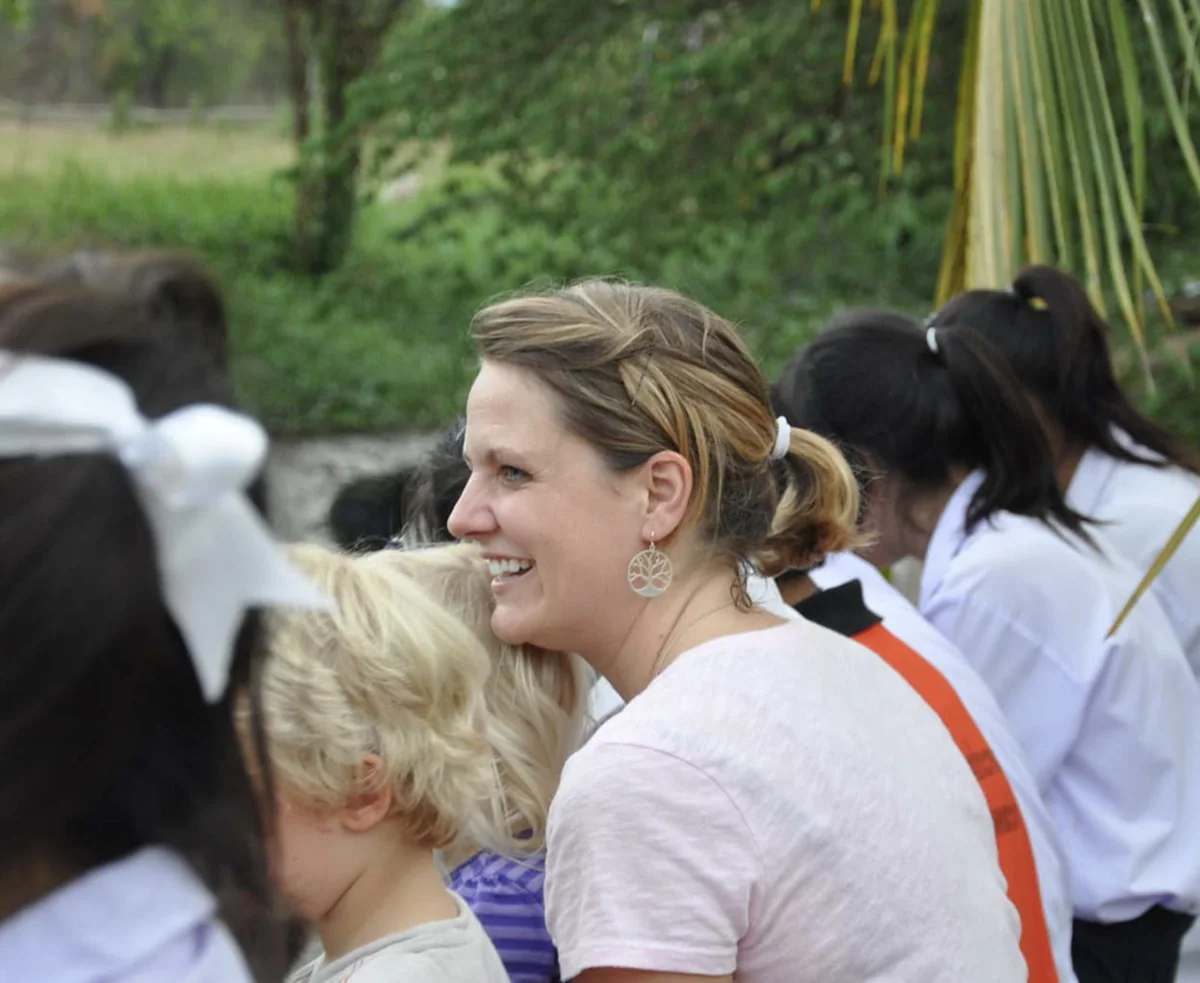 Laura Parker smiling beside a young child during her early years in Thailand